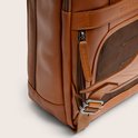 Zijkant van een bruine leren tas met mesh vak, metalen gesp en The Chesterfield Brand treklipje.