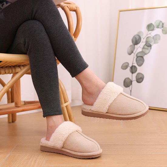 Zijaanzicht van een vrouw die op een stoel zit en beige pantoffels met pluche voering draagt.
