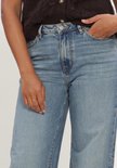 Lichtblauwe wide leg jeans met hoge taille, gedragen door een model met de hand in de zak.