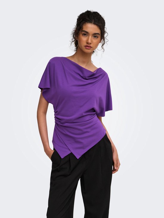 Model in een paarse ONLY top met gedrapeerde halslijn, korte mouwen en zwarte broek met wijde pijpen.