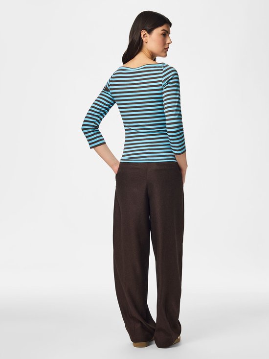 Achterkant van model in gestreept shirt met driekwartmouwen en bruine wijde broek.