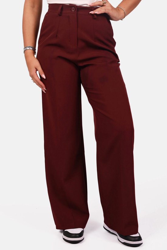 Bordeauxrode pantalon met hoge taille en wijde pijpen, gedragen met een witte top.