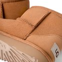 Detail van bruine UGG laarzen met naden en het UGG logo label aan de zijkant.