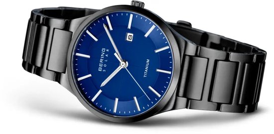Zwart titanium horloge met blauwe wijzerplaat, zilverkleurige indices en datumvenster.