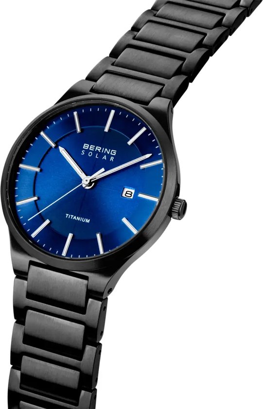 Zwart titanium horloge met blauwe wijzerplaat, datum, zilverkleurige indices en wijzers.
