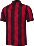 Achterkant van het rood-zwarte voetbalshirt met verticale banen en een subtiel geometrisch patroon.