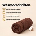 Bruine handdoek opgerold met katoenbloemen. Wasvoorschriften: wassen op max 60 graden, drogen op max 60 graden.