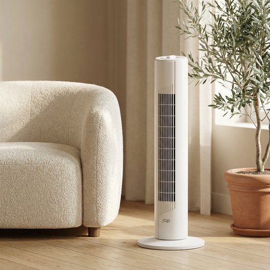 Witte JAP torenventilator met ronde voet naast een stoffen fauteuil en een olijfboom.