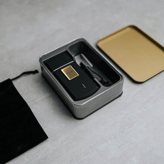 Zwarte en gouden Wahl reisscheerapparaat in metalen opbergdoos met gouden deksel.
