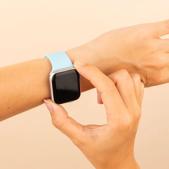 Hand die een lichtblauwe siliconen Apple Watch band om een pols doet.