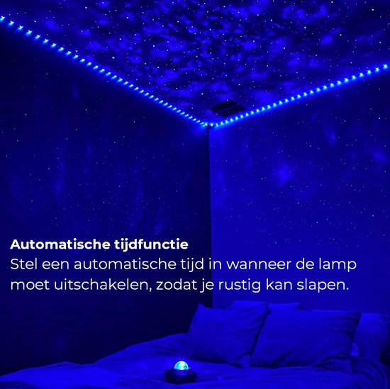 Een slaapkamer met een bed, verlicht door een blauwe sterrenhemel projectie en blauwe ledstrips langs de muren. Een galaxy projector staat op het nachtkastje.