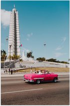 WallClassics - Poster Glanzend – Roze Auto bij Gebouw in Cuba - 50x75 cm Foto op Posterpapier met Glanzende Afwerking
