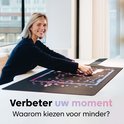 Vrolijke vrouw met blonde haren puzzelt op de Puzzlup mat met een roze/paarse puzzel.