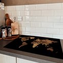 Zwarte inductiebeschermer met wereldkaartprint op een aanrecht naast een inductiekookplaat.