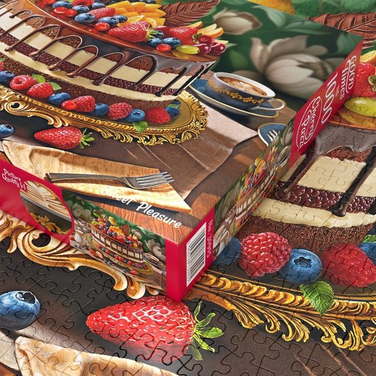 Detail van een puzzel met fruitige chocoladetaart, met close-up van de taart en een stukje van de doos.