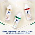 Drie flacons Nivea Luminous630 anti-spot serum: één met gouden, één met groene en één met rode rand.