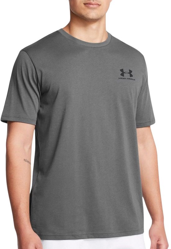 Man met grijze Under Armour T-shirt, logo en tekst op linkerborst.