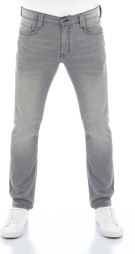 Man met grijze Mustang jeansbroek, tapered fit, met witte schoenen.