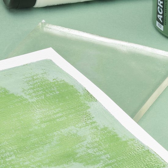 Twee transparante gelplaten op een groen textiel. De voorste plaat heeft een groene afdruk van tekst.