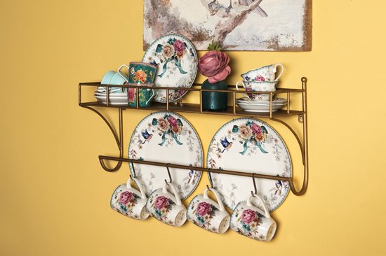 Wandrek met servies versierd met roze bloemen en vogels, inclusief kopjes, schotels en borden.