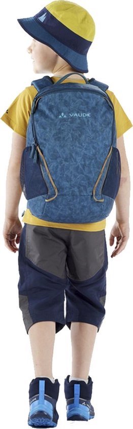 Kind draagt een blauwe rugzak met een blauw-geel gestreept petje. De rugzak heeft een print.