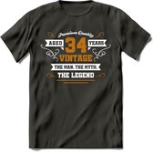 34 Jaar Legend T-Shirt | Goud - Wit | Grappig Verjaardag en Feest Cadeau Shirt | Dames - Heren - Unisex | Tshirt Kleding Kado | - Donker Grijs - XL