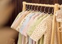 Een rij baby slaapzakken in zachte pasteltinten en met diverse dierenprints, waaronder konijntjes, beren en koeien.
