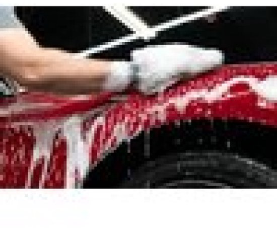 Man wast een rode auto met schuimend autoshampoo.
