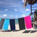 Vijf handdoeken hangend aan een waslijn: zwart, lichtblauw, marineblauw, zwart, felroze.