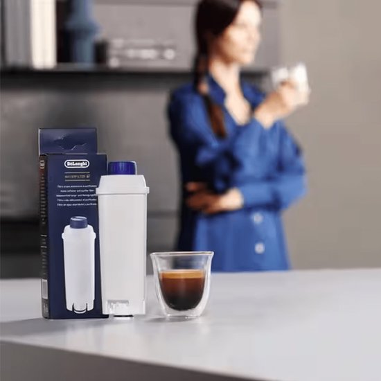 Wit De'Longhi waterfilter met blauwe dop, naast een doos en een espresso kopje.