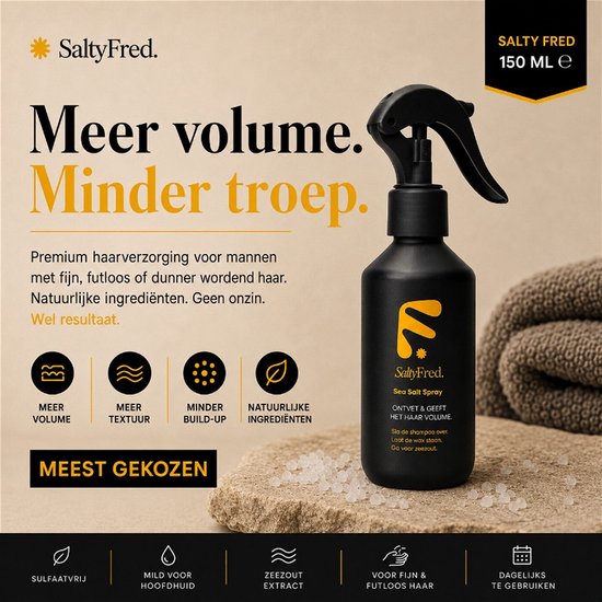 Zwarte spuitfles SaltyFred Sea Salt Spray op steen, met tekst over meer volume en minder troep. Natuurlijke ingrediënten, meer textuur, minder build-up.