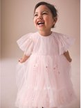 Meisje in een roze, off-shoulder mesh feestjurk met korte mouwen, bloemen-appliques en ruches, lachend.