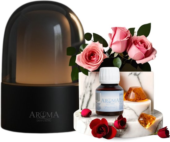 Zwarte aroma diffuser met glanzende kap, naast een marmeren display met roze rozen en een flesje geurolie.