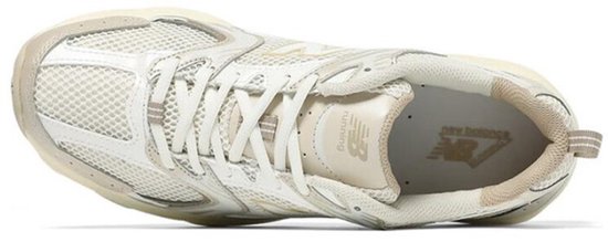 Bovenaanzicht van een beige New Balance 530 sneaker met 'Running' op de binnenzool.
