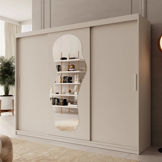 Beige kledingkast met schuifdeuren, organische spiegel en zicht op een open kast met boeken.
