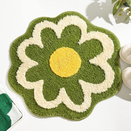 Groen badmatje in bloemvorm met een geel hart en witte bloemblaadjes, gemaakt van zacht, pluizig materiaal.