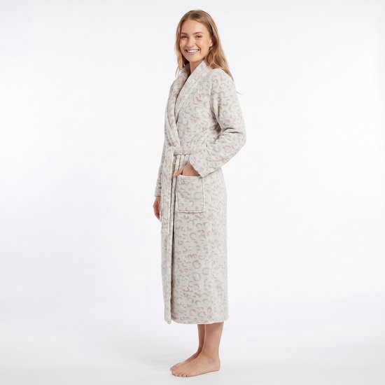 Vrouw staand in een zachte, lange, beige badjas met panterprint en ceintuur.