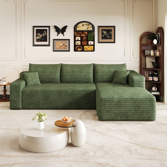 Groene corduroy modulaire L-vormige bank met chaise longue, met horizontale ribbels en losse kussens.