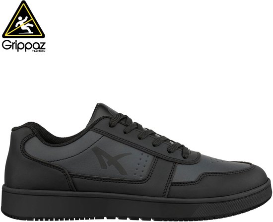 Zwarte sneaker met veters, donkergrijs detail, logo en een waarschuwingssticker.