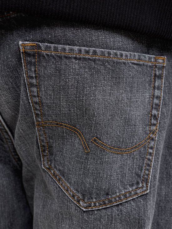 Close-up van de achterzak van een grijze jeans met stiksels.