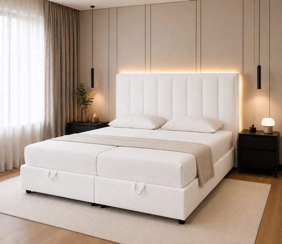 Wit tweepersoons matras met gestoffeerd hoofdbord en opbergvakken in de ombouw.