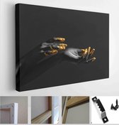 Hands of woman with black and golden paint on her skin against dark background - Modern Art Canvas - Horizontal - 1194970093 - 115*75 Horizontal