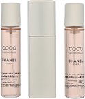 Drie flacons Coco Mademoiselle Eau de Toilette van Chanel met gouden dopjes, naast een zilverkleurige verstuiver.