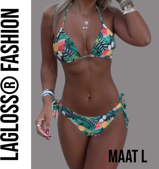 Model draagt een bikini met tropische print van bladeren, bloemen en fruit. Haltertop met strikbroekje.