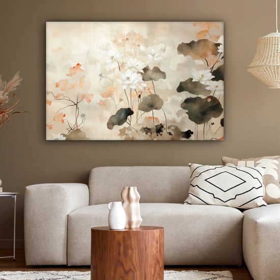 Bruin getinte woonkamer met een canvasprint van witte lotusbloemen en bruine bladeren, boven een lichte bank.