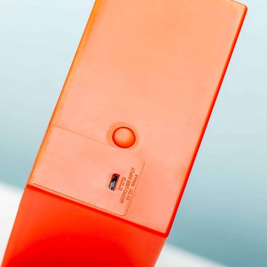 Oranje achterkant van de lamp met micro-USB ingang en batterijvak.