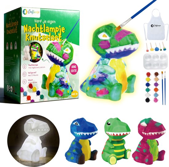 Deel van een knutselset: doos, een wit dinosaurus nachtlampje, geschilderde dinosaurus, verf, penselen, sponsjes en schort. Vier dinosauriërs op een rij: wit, blauw met geel, groen met strepen, roze met groen.