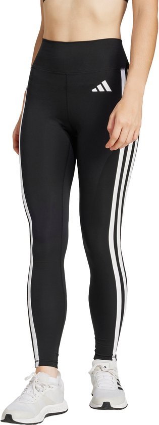 Model in zwarte legging met witte Adidas strepen op de zijkanten en witte sneakers