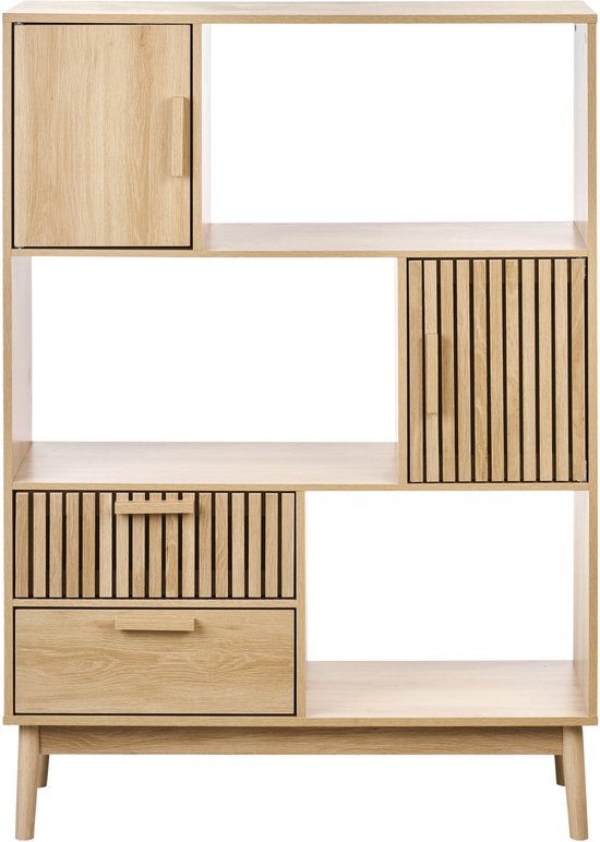 Lichte houten boekenkast met open vakken, een lade met ribbels en een deur met ribbels.