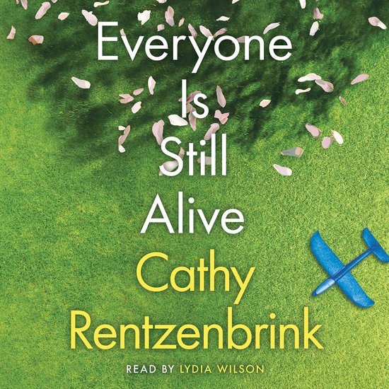 Boekcover met de titel 'Everyone Is Still Alive'. Een blauw vliegtuigje ligt op een groen gazon met roze bloesemblaadjes.